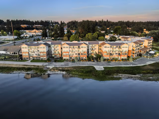 An aerial view of Crista Shores senior living buildings beside a calm river.