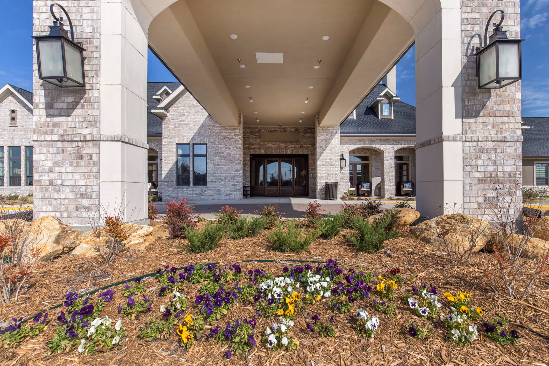 Front entrance of Briarview Senior Living with stone pillars and landscaped flower bed.