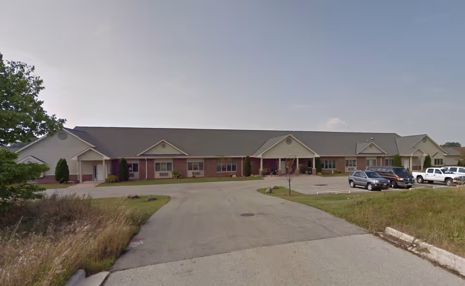 Single-story senior living facility exterior with brick facade and a parking lot.