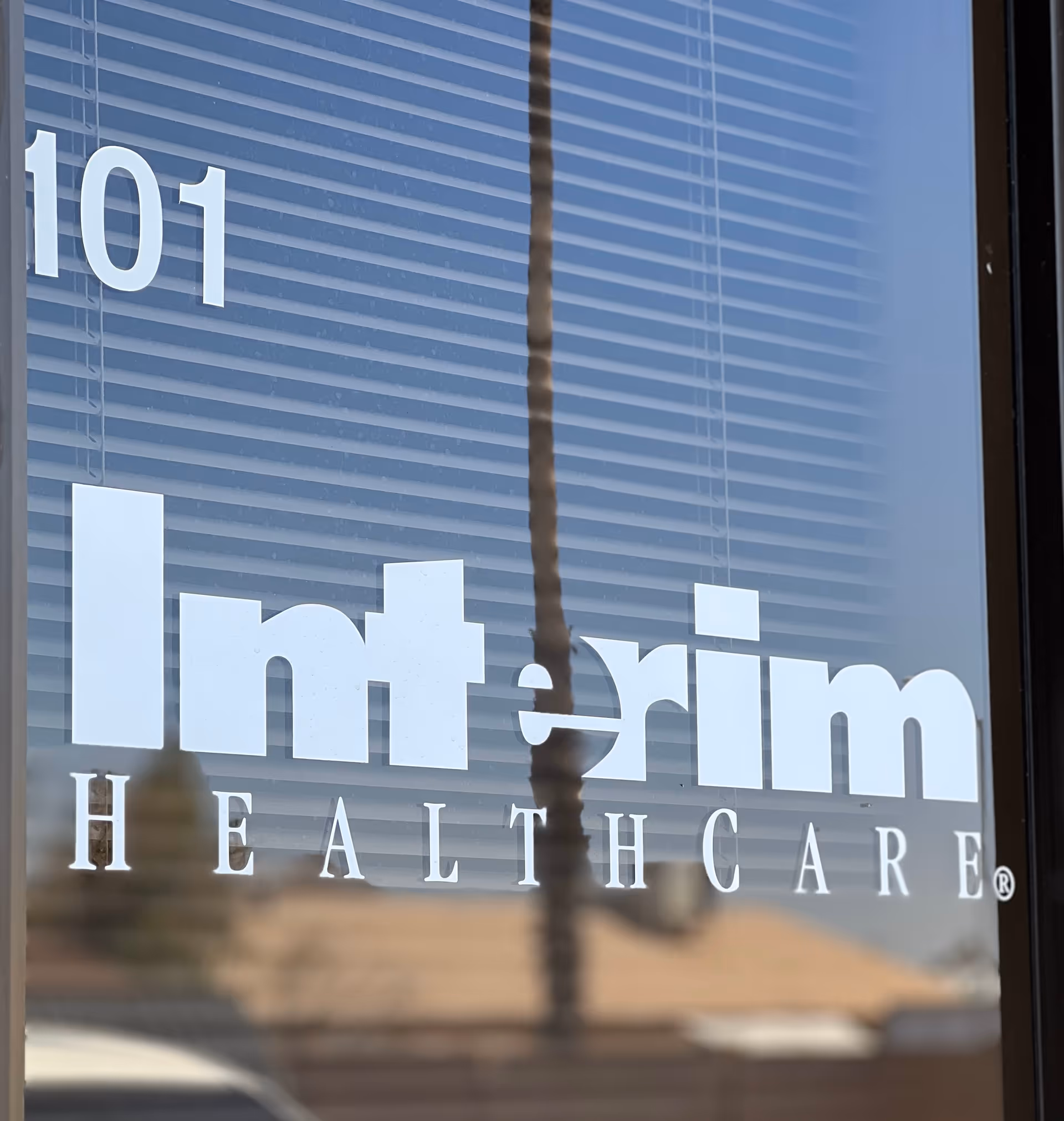 Building-front glass door with Interim HealthCare logo and the number 101.