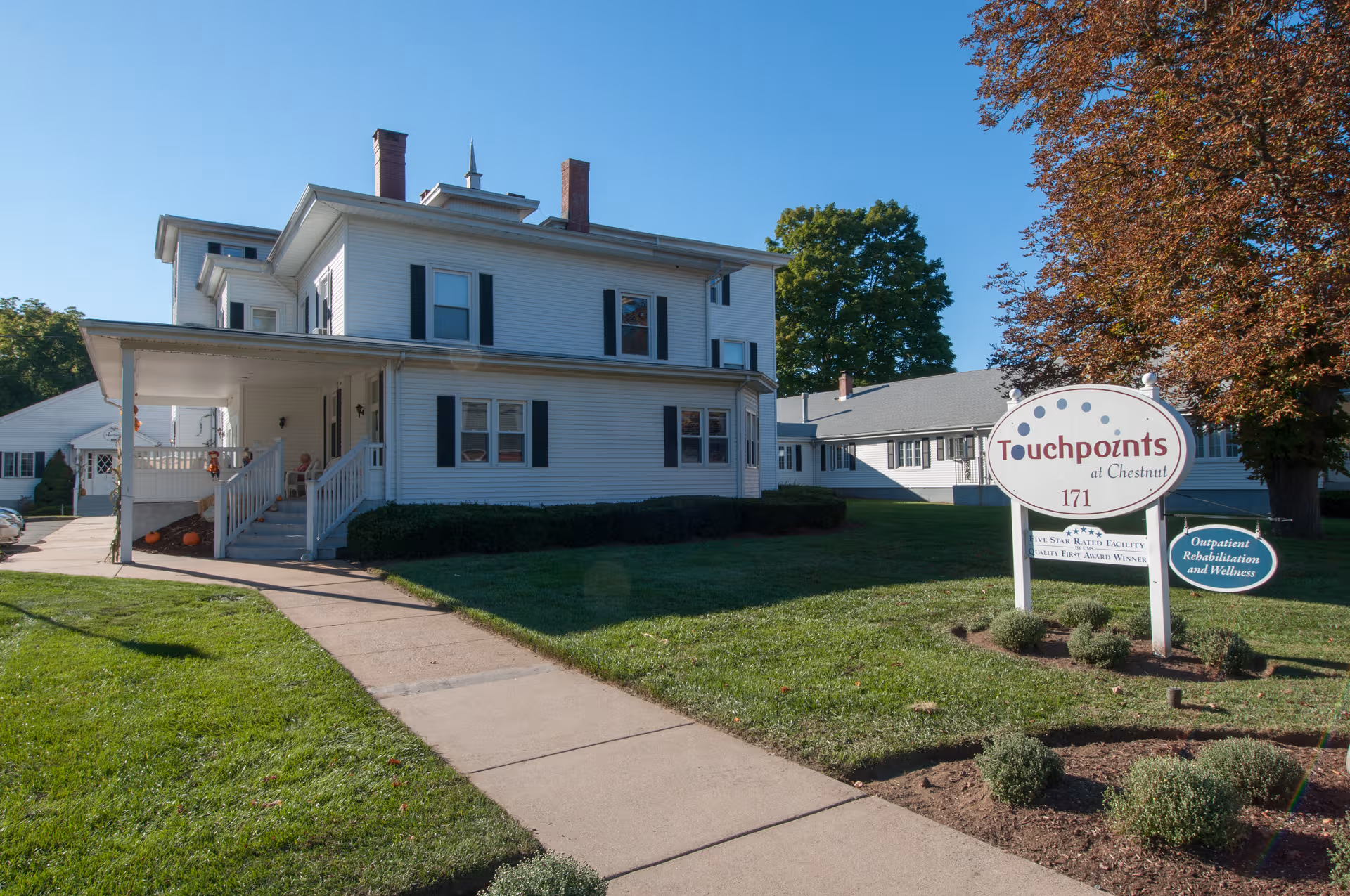 Exterior view of Touchpoints at Chestnut facility with sign, walkway, and lawn.