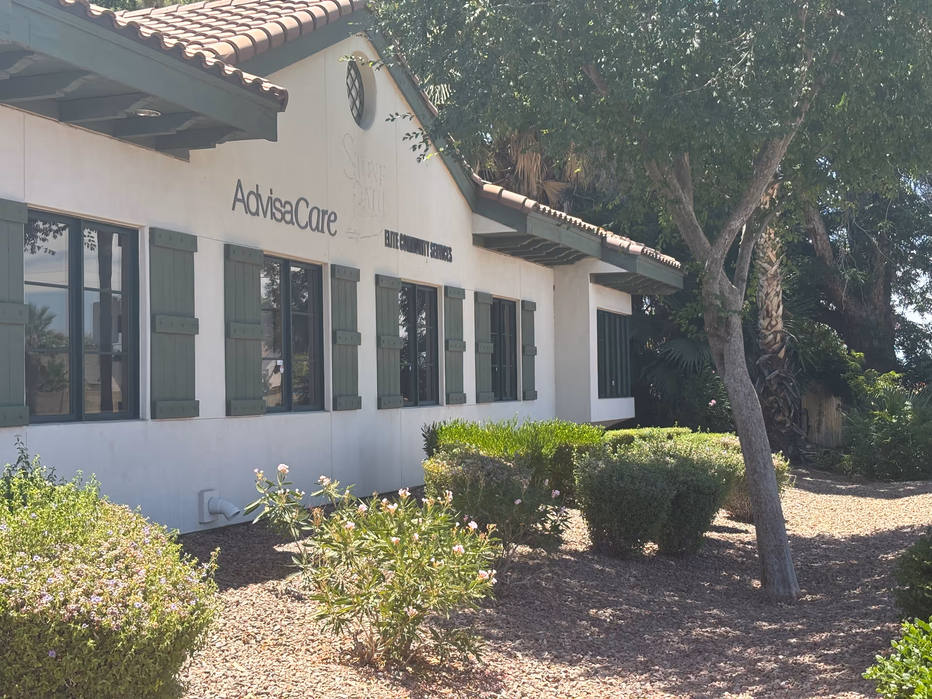 Exterior view of AdvisaCare facility with windows and greenery