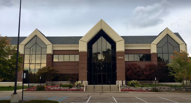 A brick CareOne Senior Care facility with a glass-front entrance and landscaped front grounds.