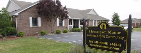 Brick assisted living facility with a front entrance and a sign reading Hometown Manor.