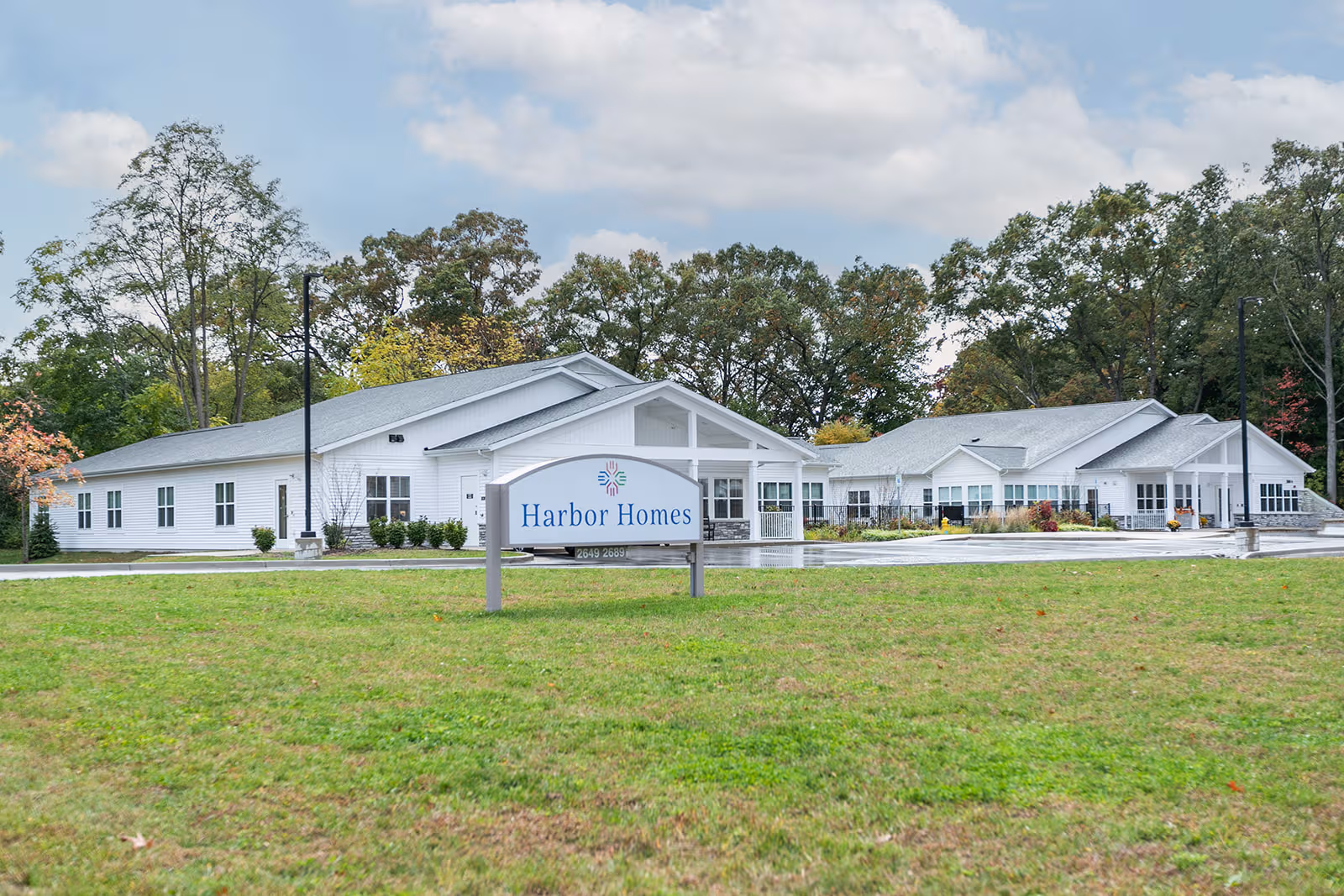 White, single-story Harbor Homes building with a sign reading Harbor Homes Assisted Living & Memory Care.