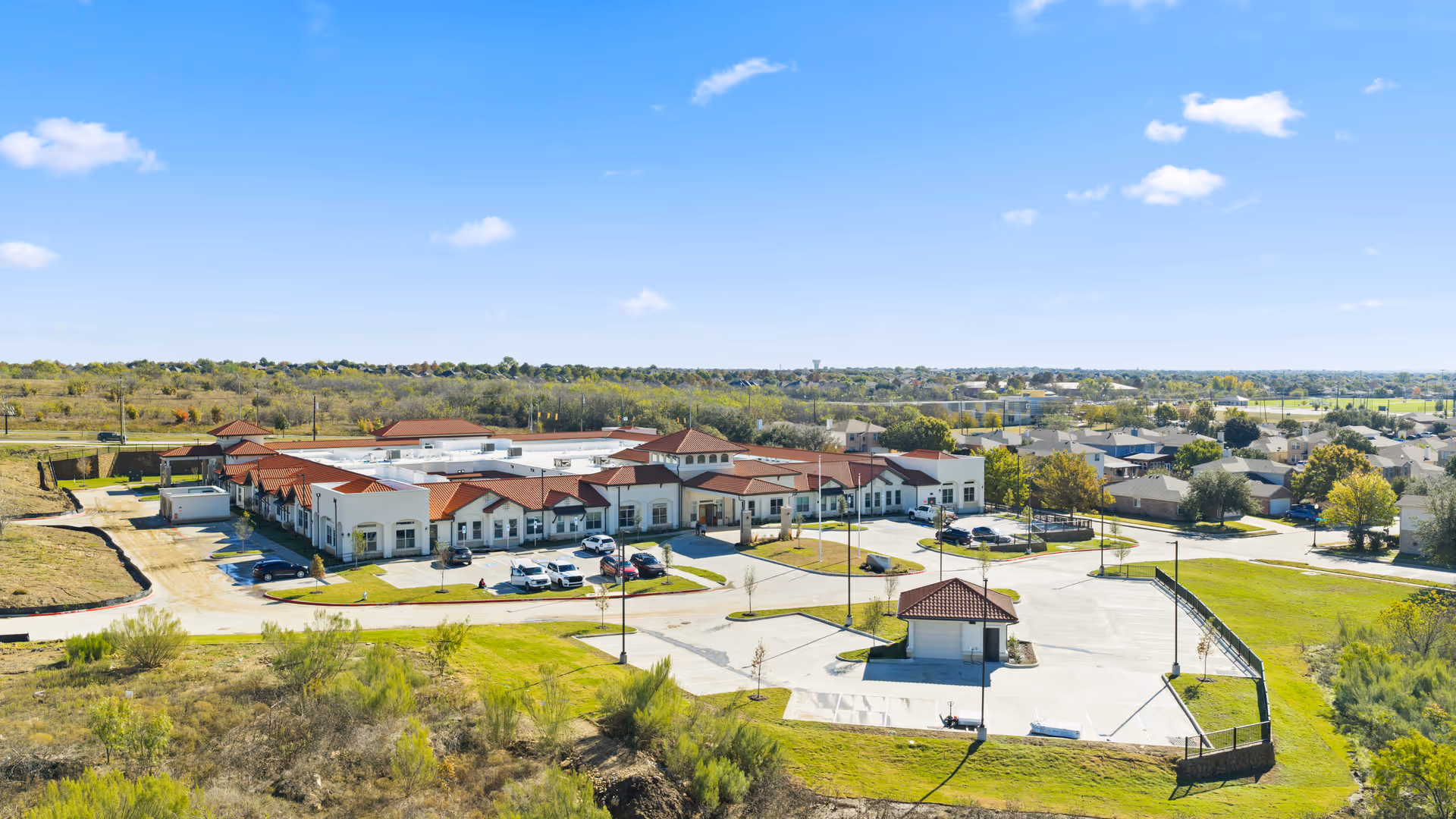 Aerial view of The Emberly at Heritage Glen campus with red roofs and parking.