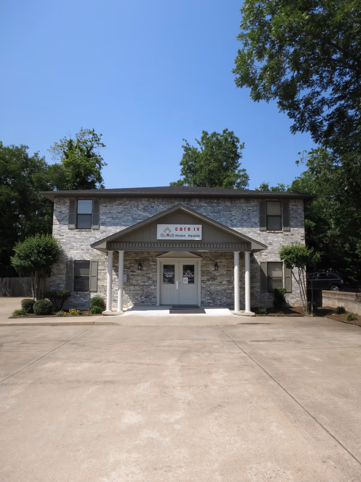 Single story brick facility with a covered entrance and Care IV Home Health sign.