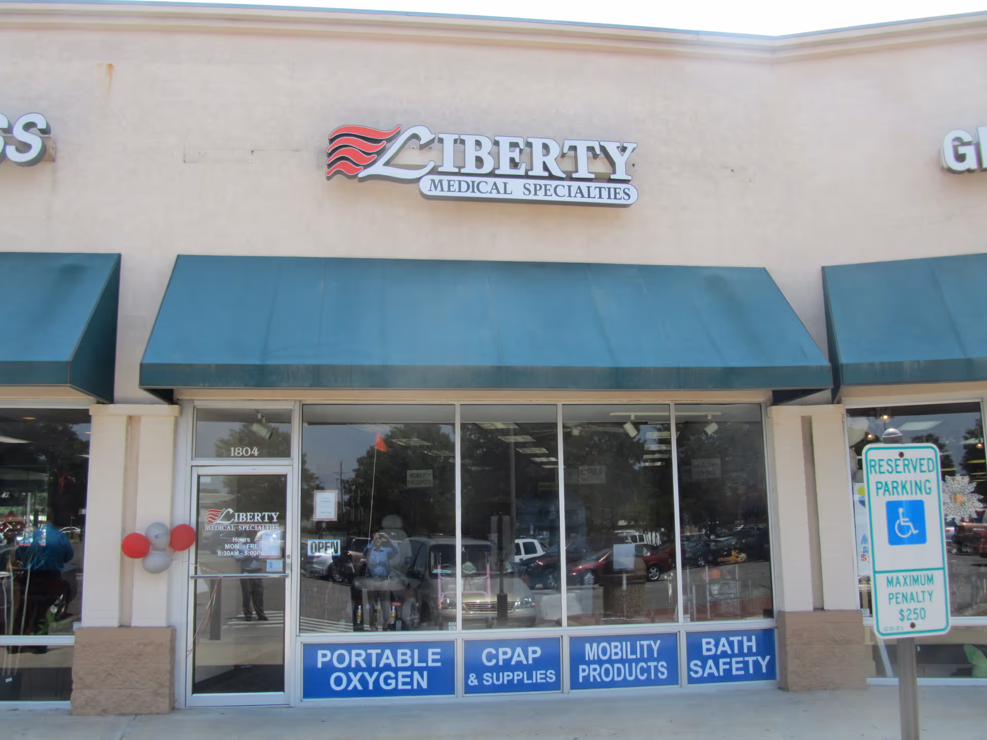Exterior storefront of Liberty Medical Specialties with teal awnings and glass doors.