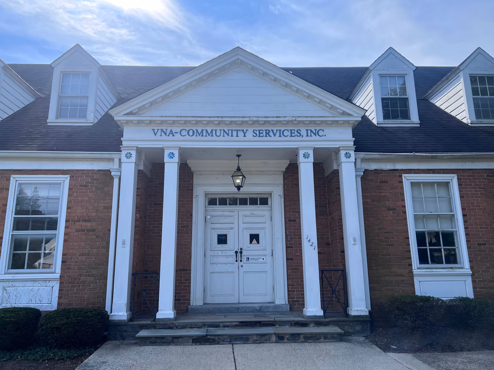 Brick building with white columns and a pediment, labeled VNA-Community Services, Inc.