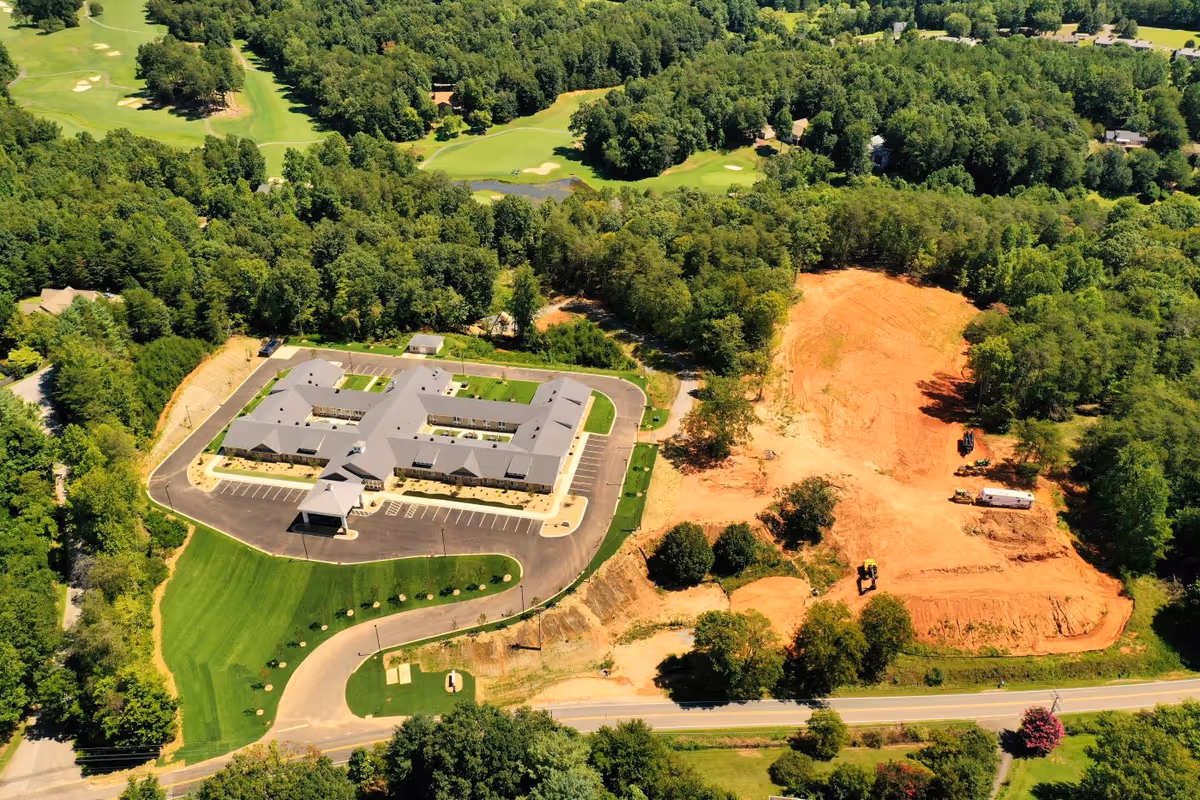 Aerial view of The Landings of Lake Lure campus with parking, greenery, and a construction site