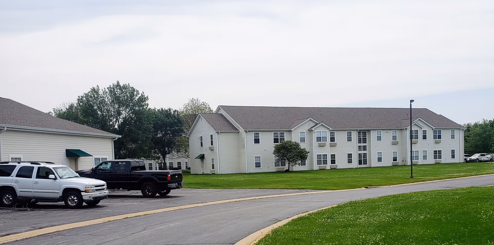 Exterior view of The Pointe at Jacksonville building with green lawn and parked vehicles.