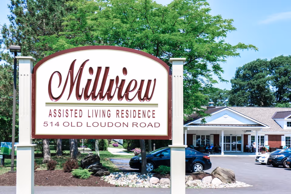 Large Millview Assisted Living Residence sign in front of the facility entrance and parking area.