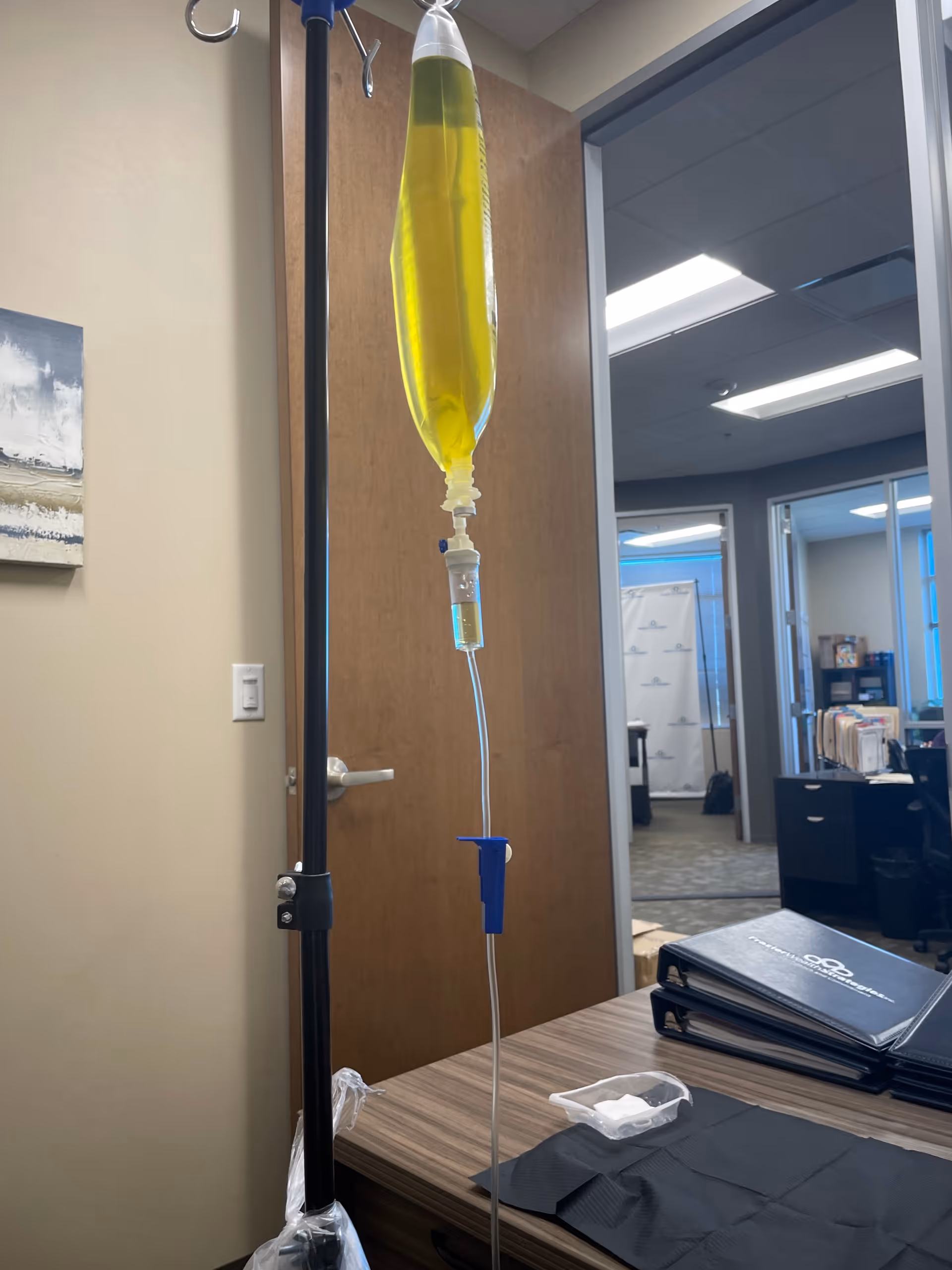 IV drip bag and pole suspended in a small office-like exam room