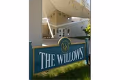 The Willows sign in front of a light-colored senior living building exterior.