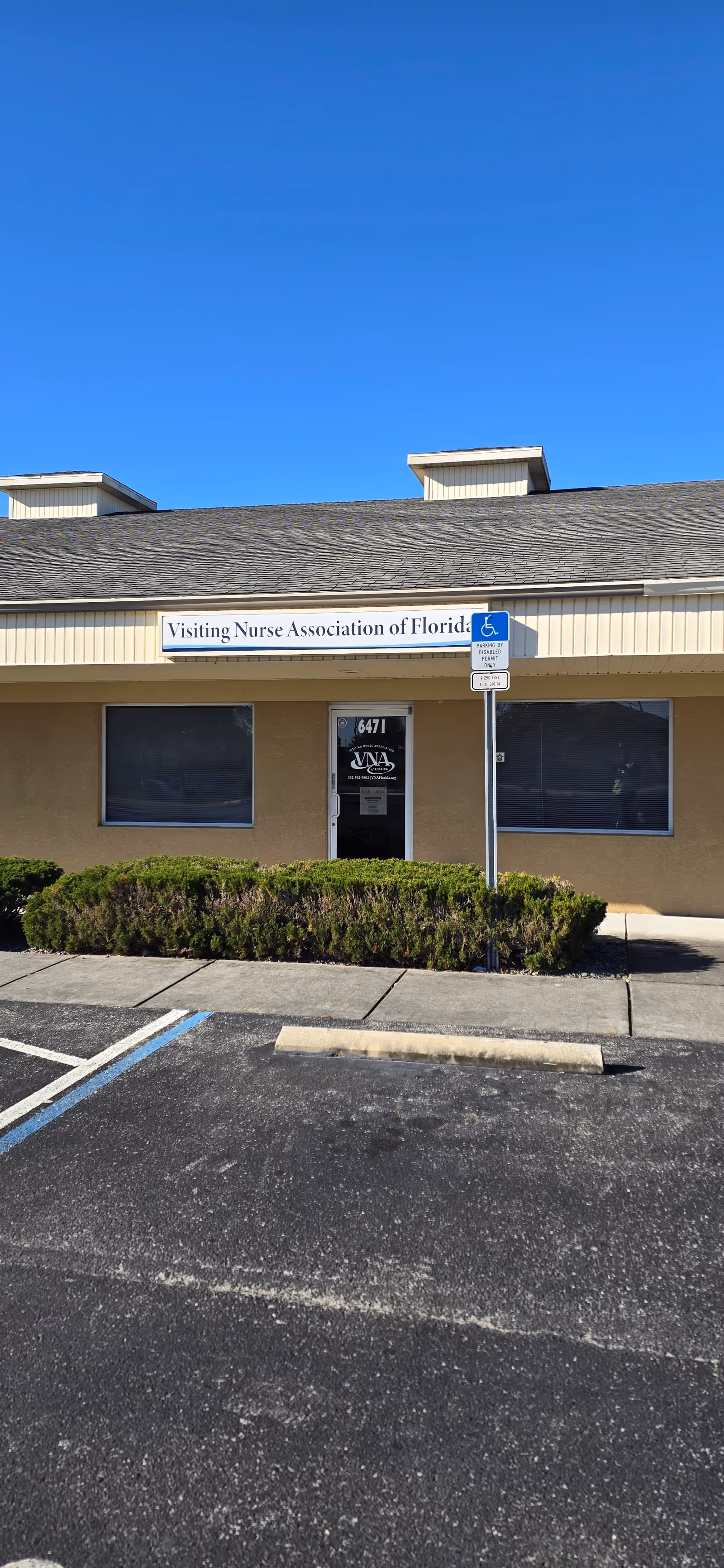 Blue sky above the front exterior of Visiting Nurse Association of Florida building with handicap parking.