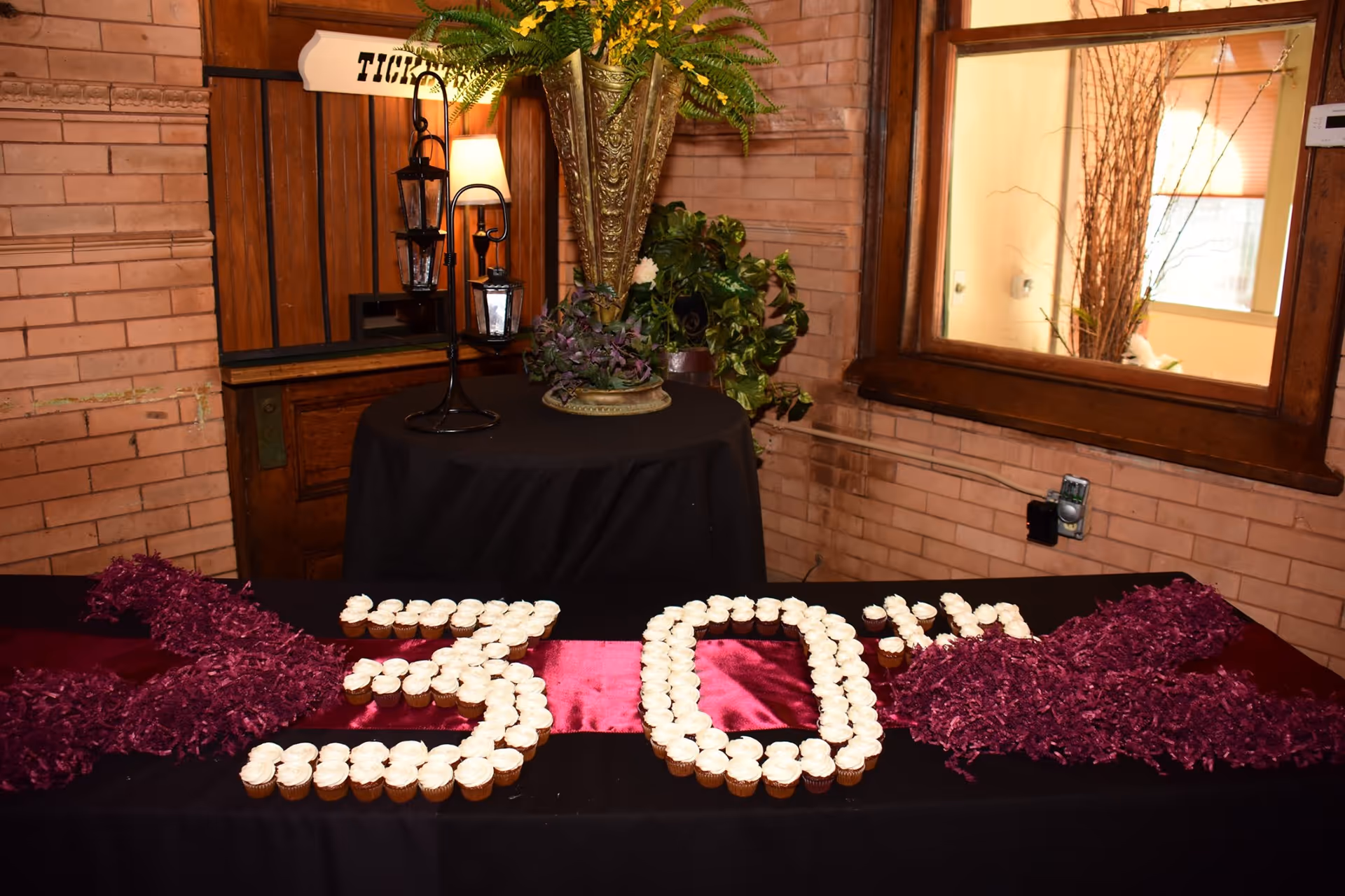 Indoor event table with cupcakes arranged to form the number 30.