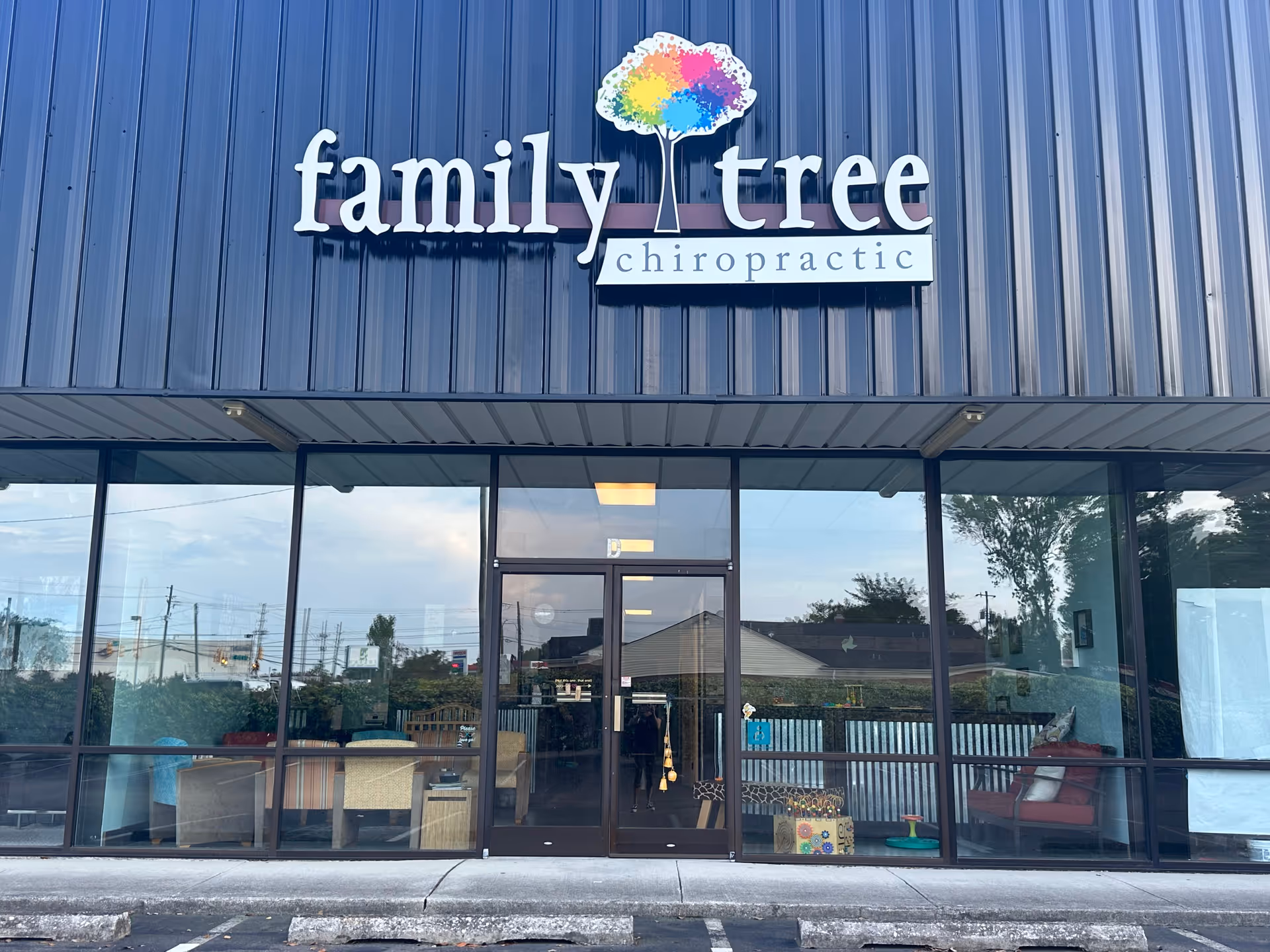 Exterior storefront with large glass windows and a family tree chiropractic sign.