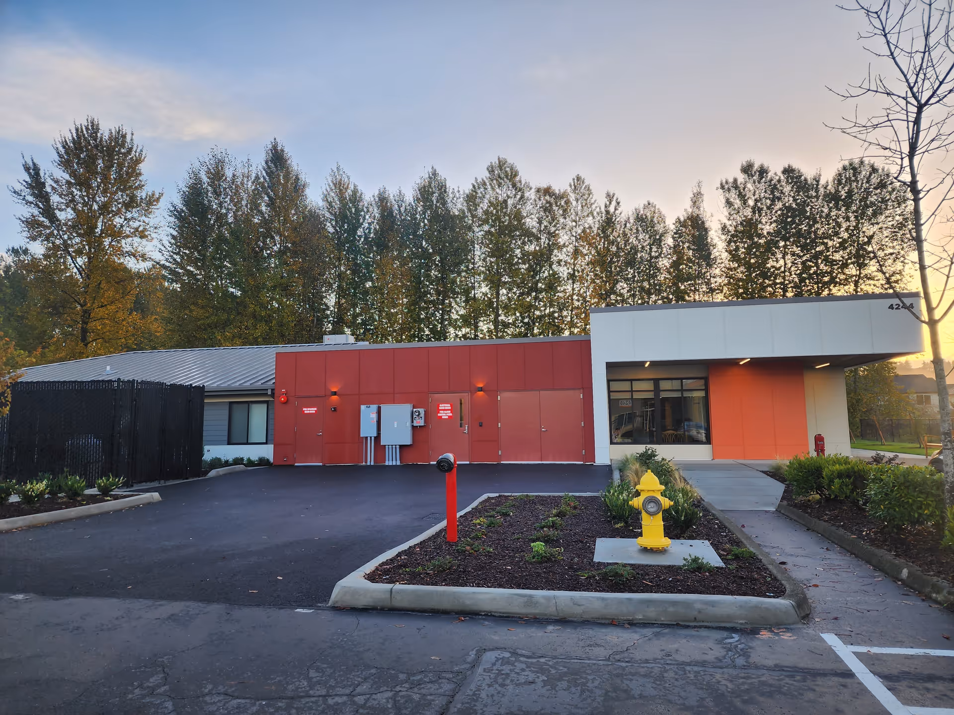 Exterior view of Parks Place senior living facility with red and white facade and parking lot