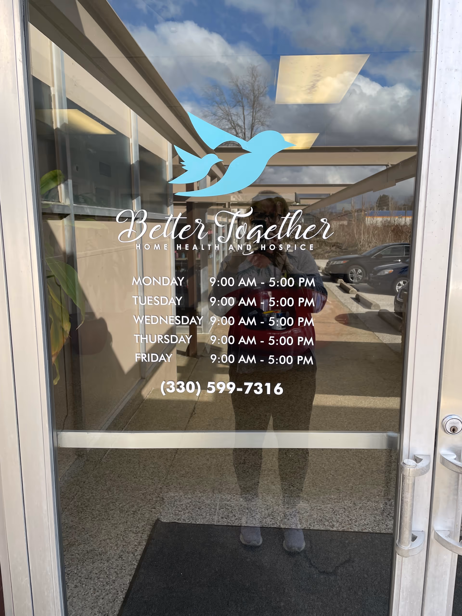 Glass entrance door displaying Better Together logo and weekly hours.