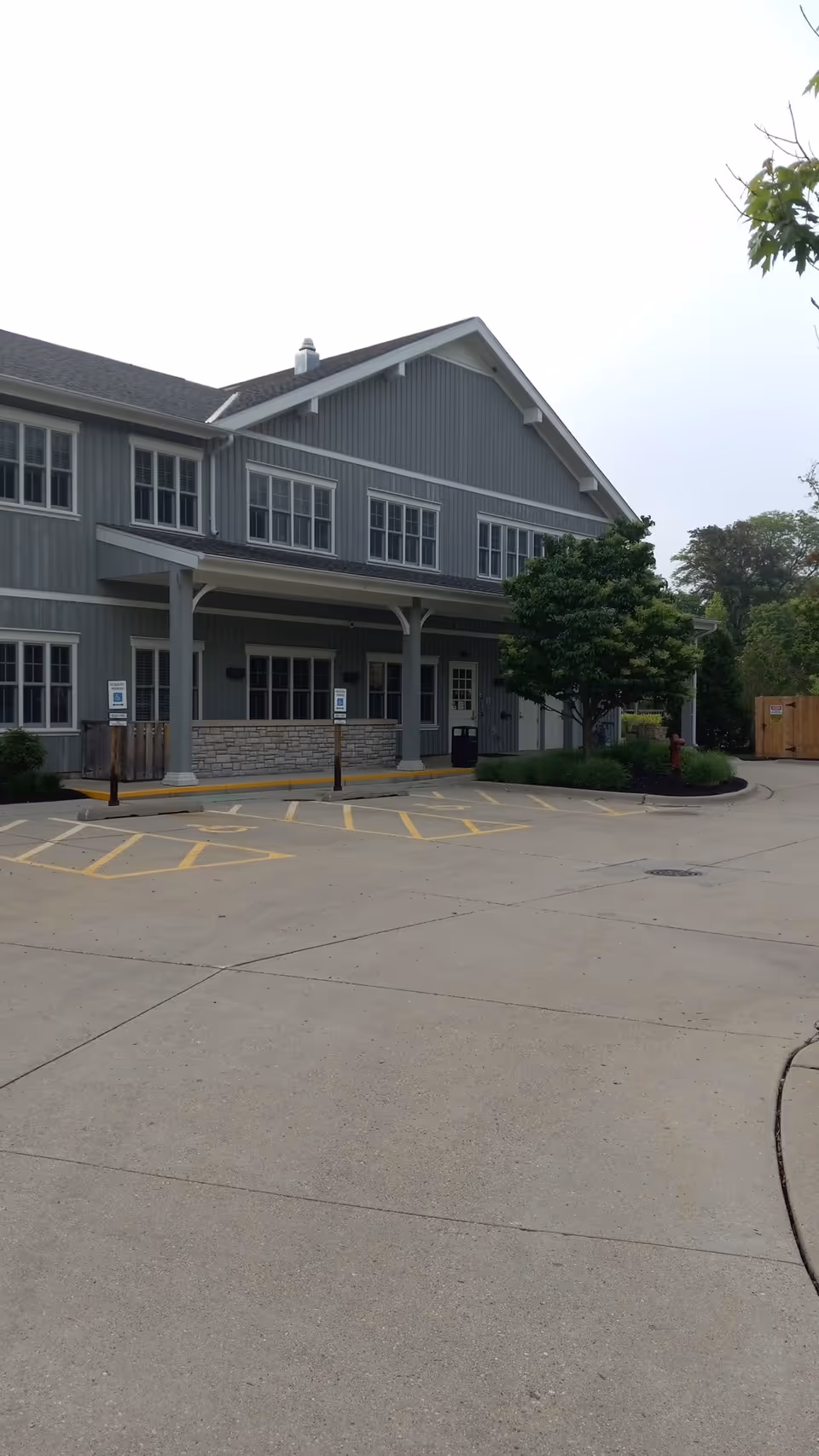 Exterior view of JourneyCare Hospice facility with entrance, parking, and trees.