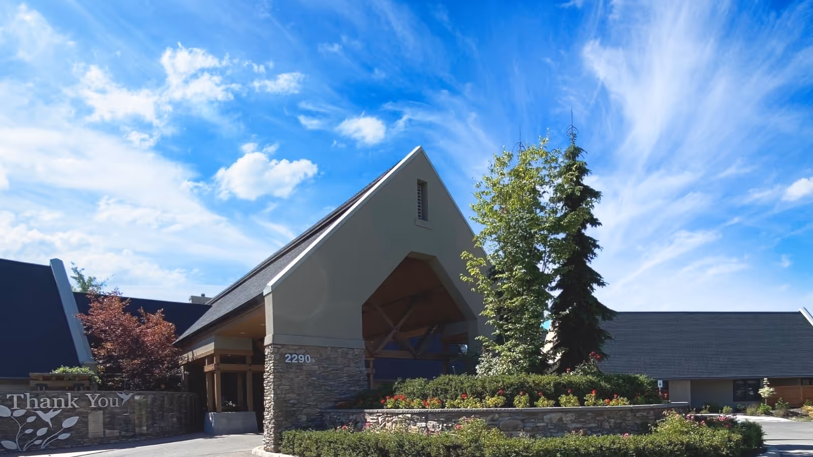 Front exterior of Hospice of North Idaho building with stone accents and landscaped entrance.