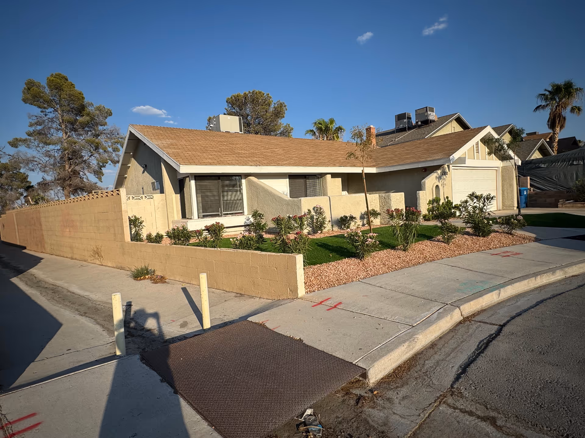 Front view of a single-story beige care home with a landscaped yard.