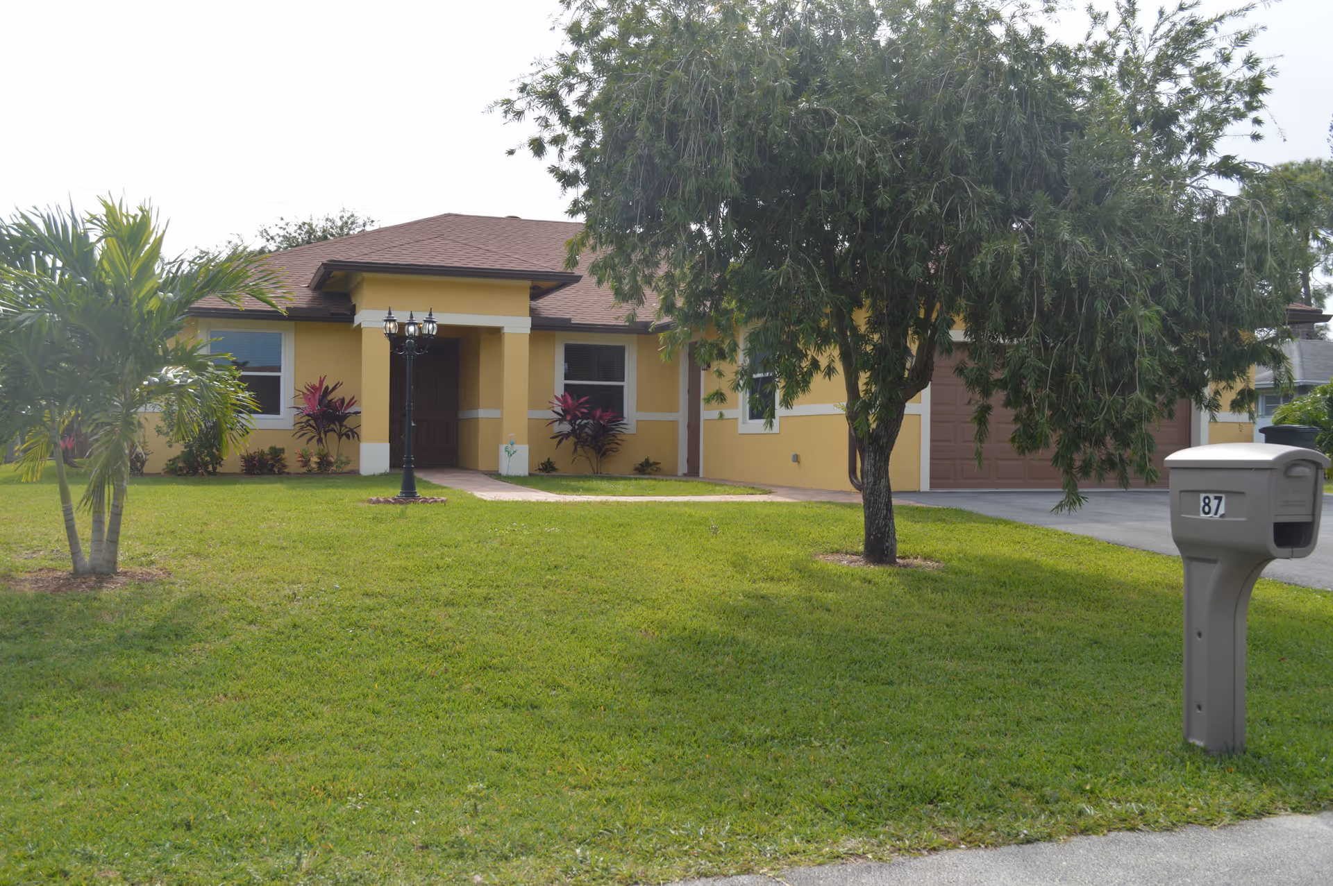 Front exterior of Path of Life of Lake Worth with lawn and mailbox.