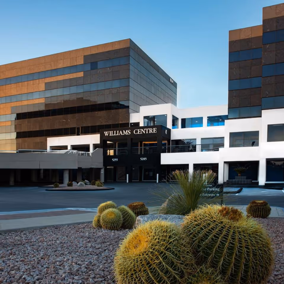 Exterior view of a modern building front with desert landscaping and a Williams Centre sign.