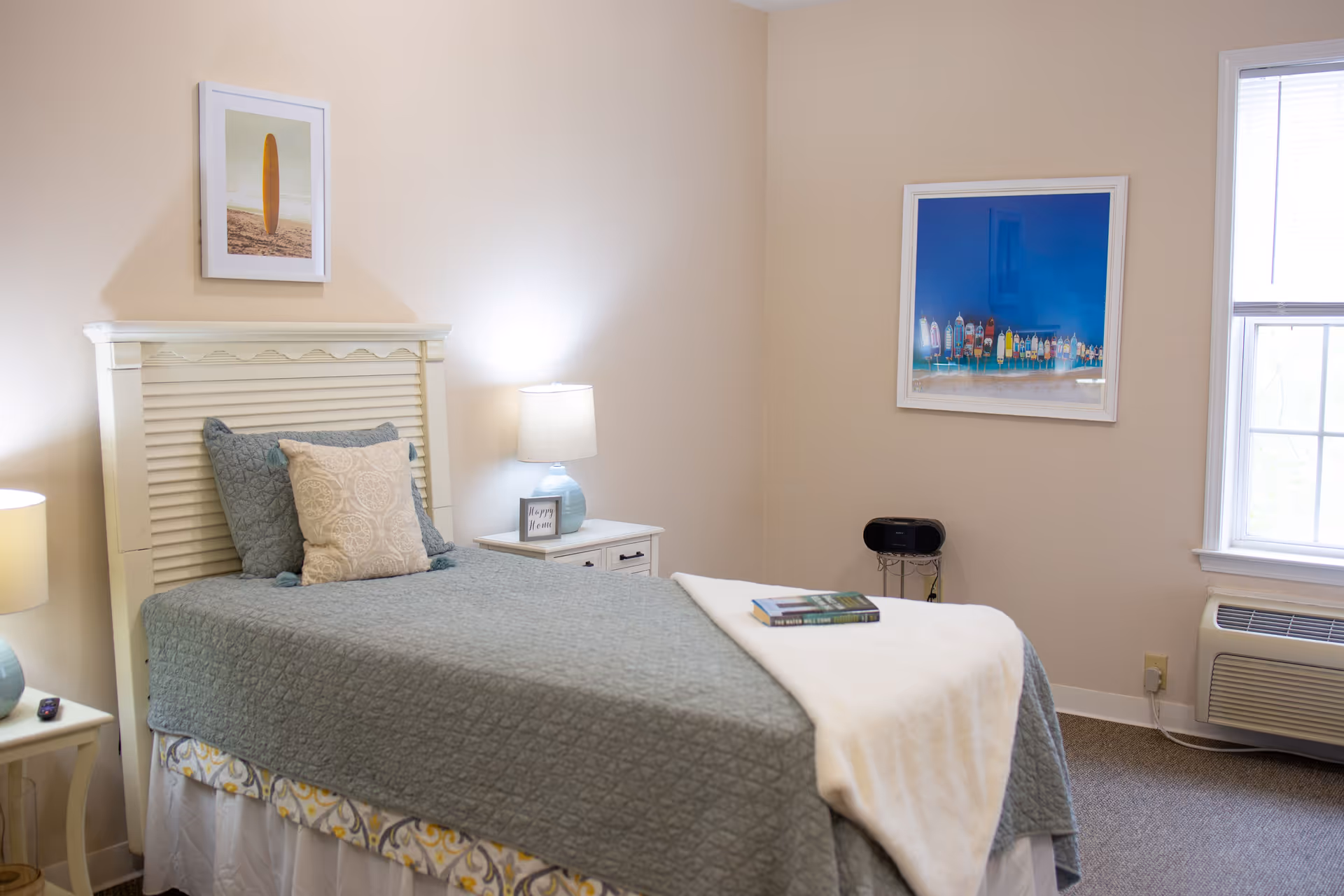 A neatly arranged bedroom with a bed, nightstands, lamps, and framed art.