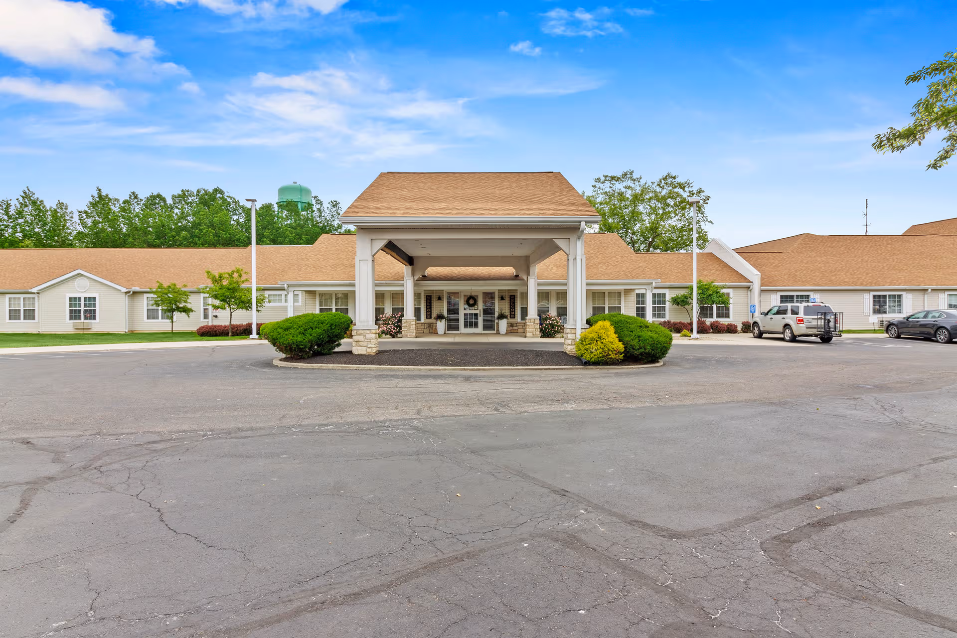 Front view of Carroll Place facility with covered entrance and parking.