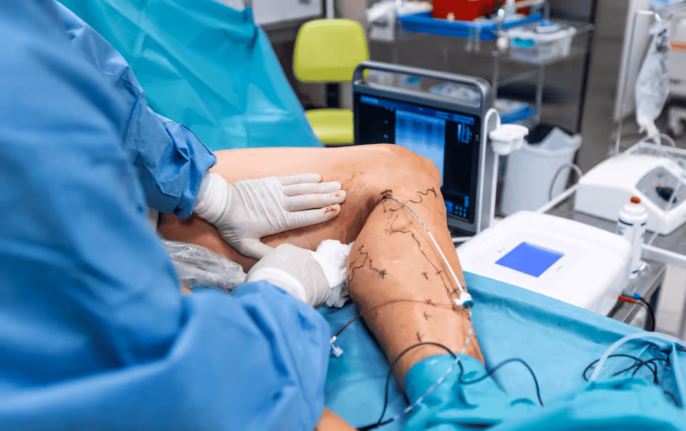 Surgeon in blue scrubs performs leg surgery in a sterile operating room.