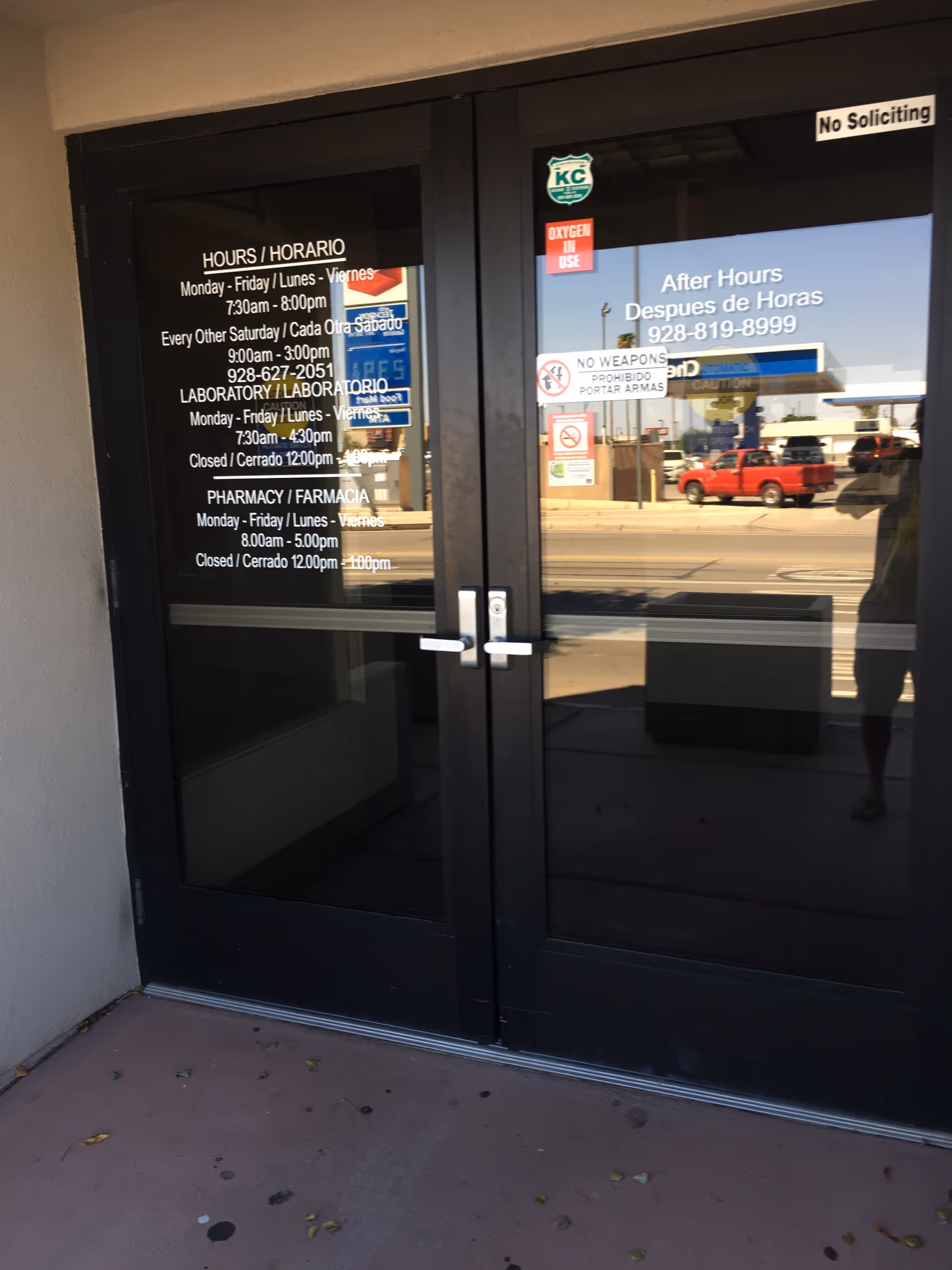 Double glass doors displaying hours and notices at facility entrance.