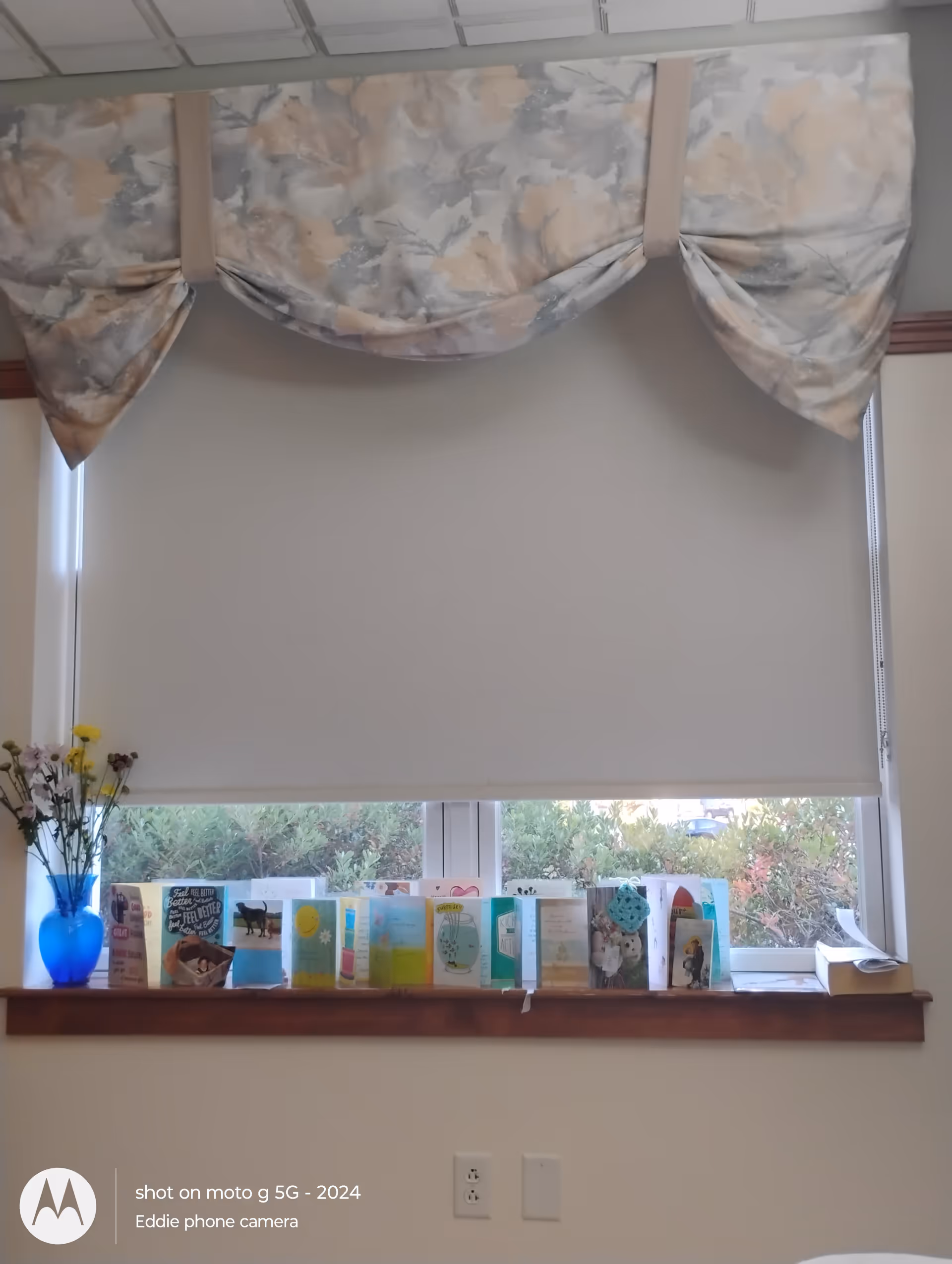Interior window scene with decorative valance and greeting cards on the sill.