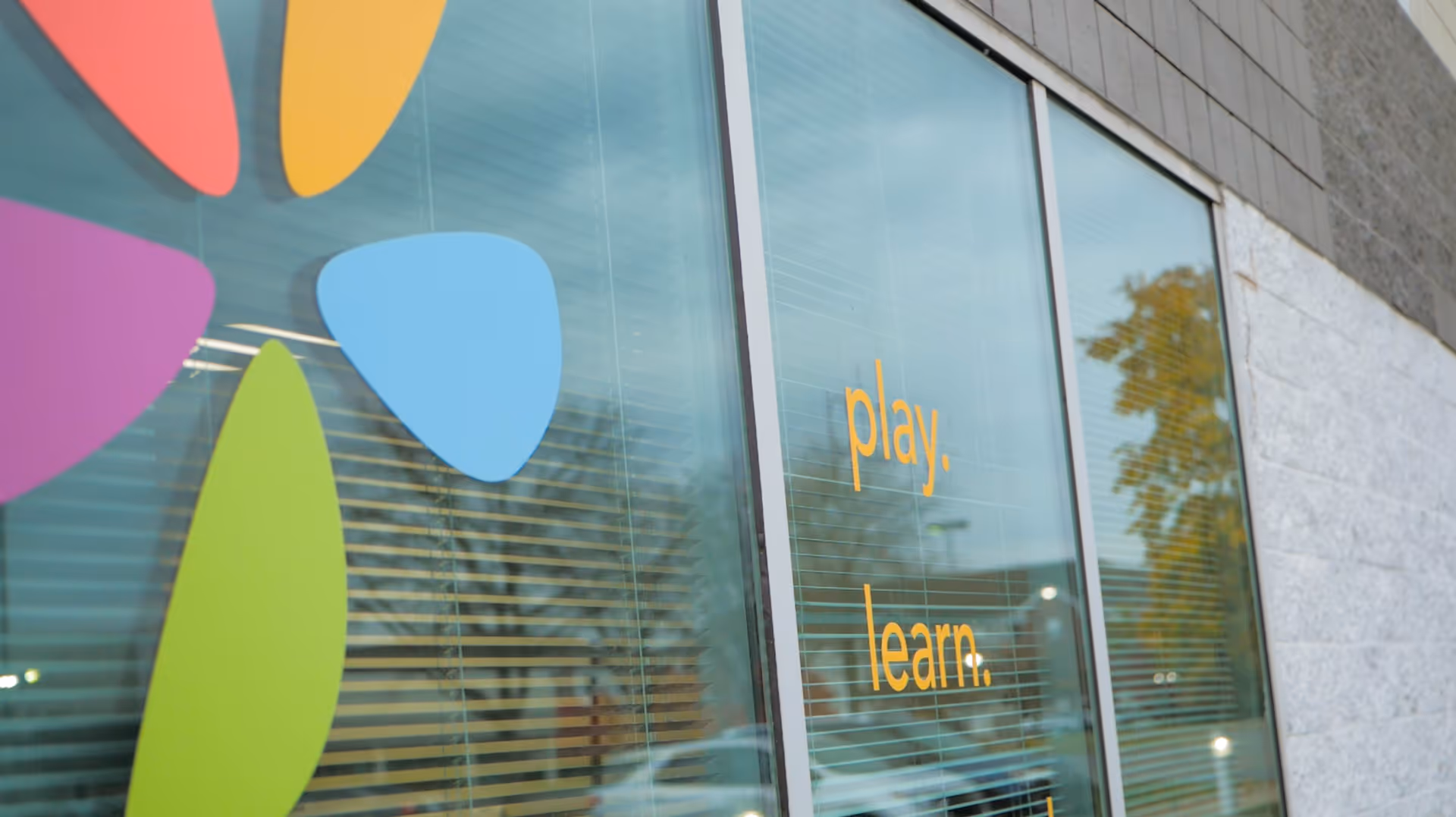 Exterior glass windows with colorful shapes and the words play and learn.