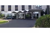 Exterior view of Saint Joseph Villa entrance with a covered driveway and cars.