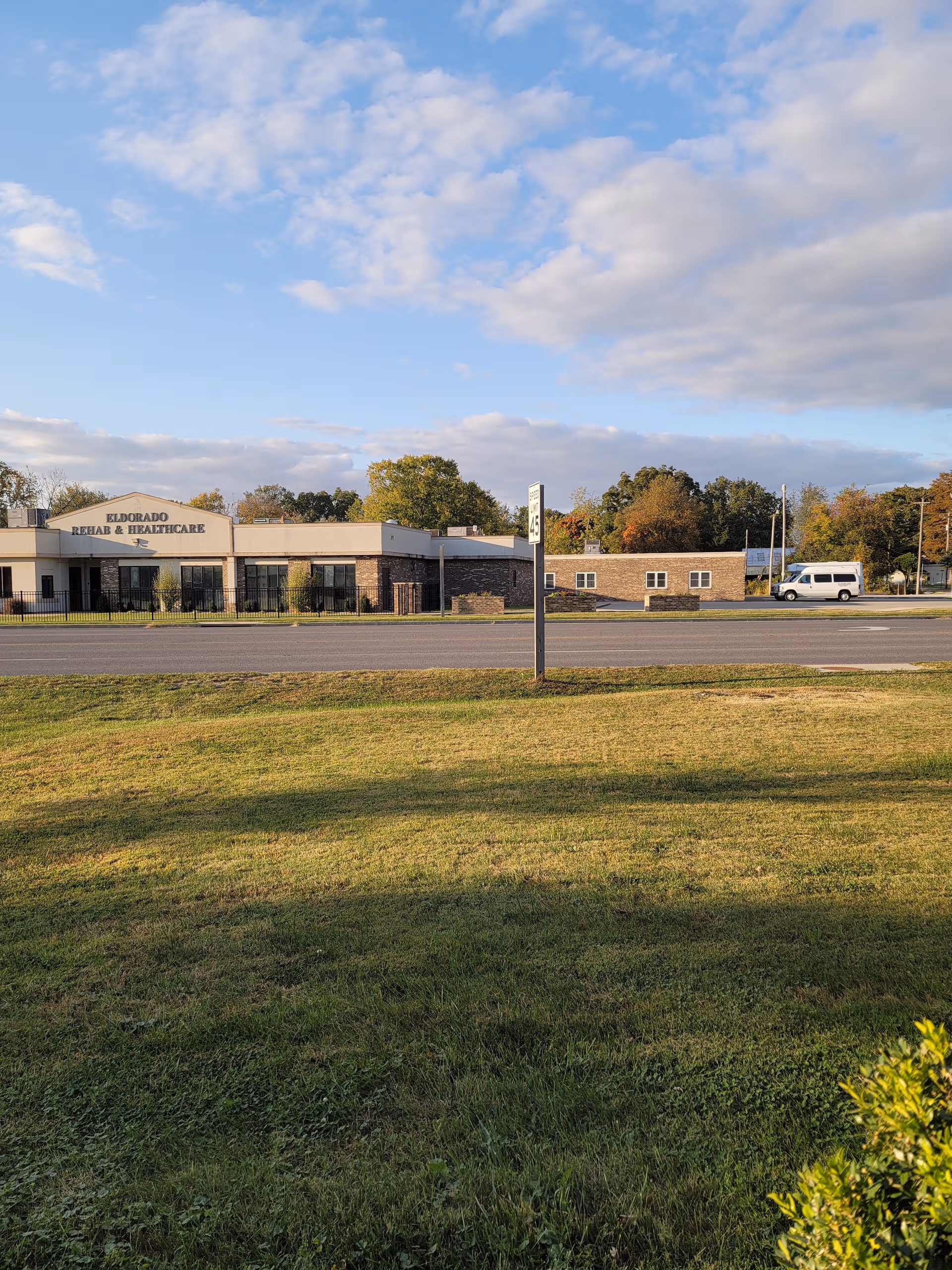 Exterior view of Eldorado Nursing and Rehabilitation Center along a road with grassy foreground.