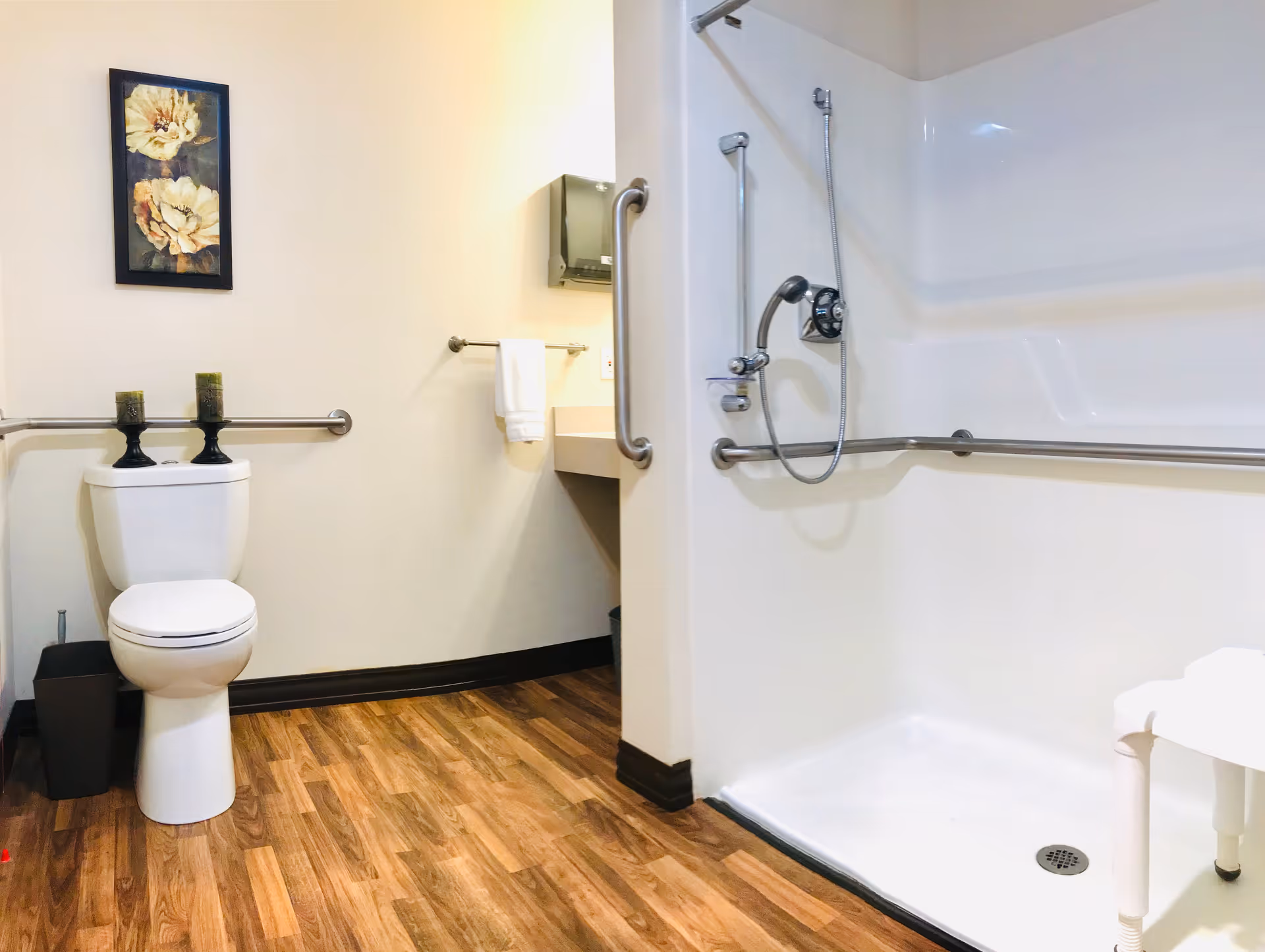 Accessible bathroom in Truewood by Merrill Boise: toilet, shower, grab bars, wood-like flooring.