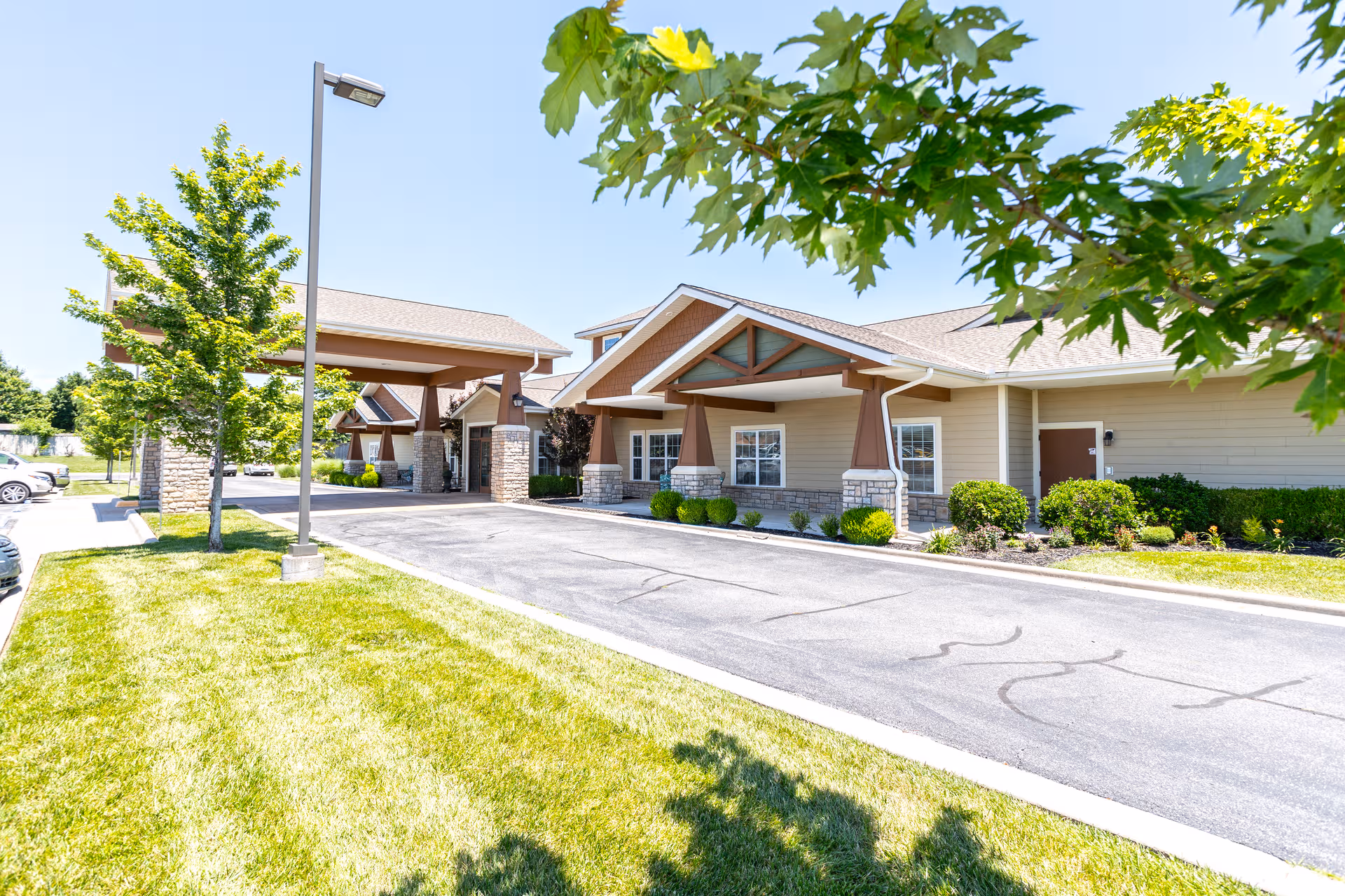 Exterior view of Oak Pointe of Monett facility with entry canopies and a parking lot.