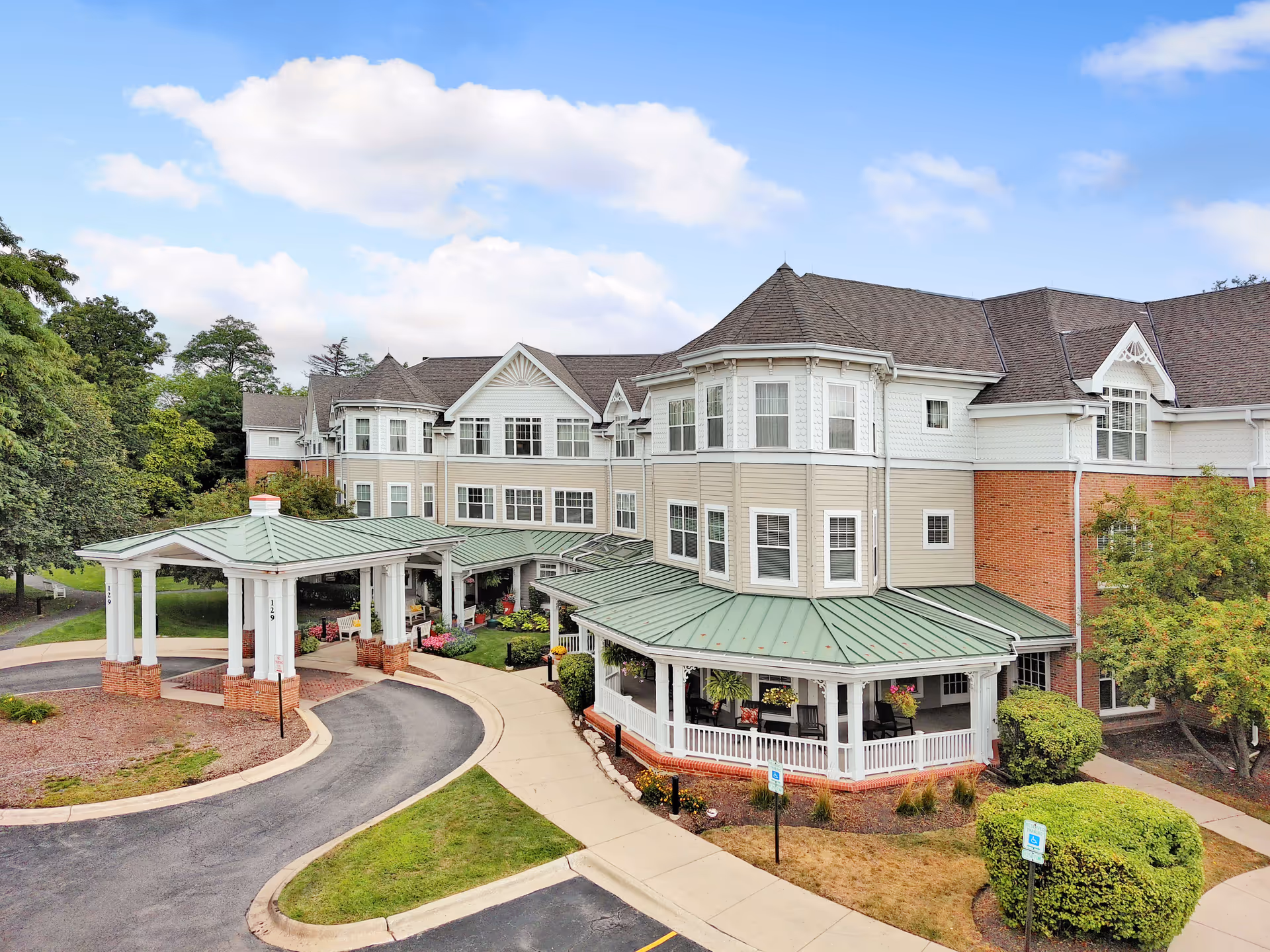 Multi-story senior living facility exterior with a covered entrance and circular driveway.