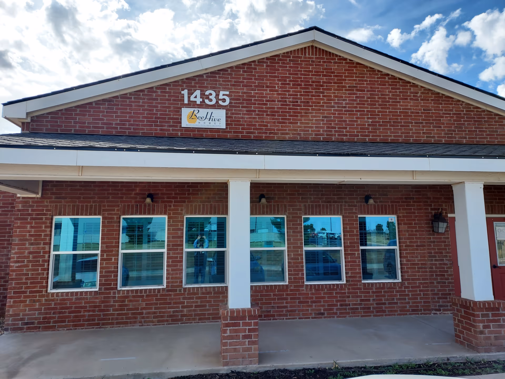 Brick building exterior with 1435 address and BeeHive Homes sign on the front.