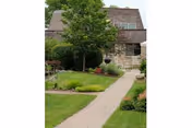 Front exterior of Willow Ridge Healthcare with a stone facade, walkway, and landscaped front yard.