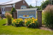 Front view of Golden Crest Nursing Centre sign with yellow flowers and greenery