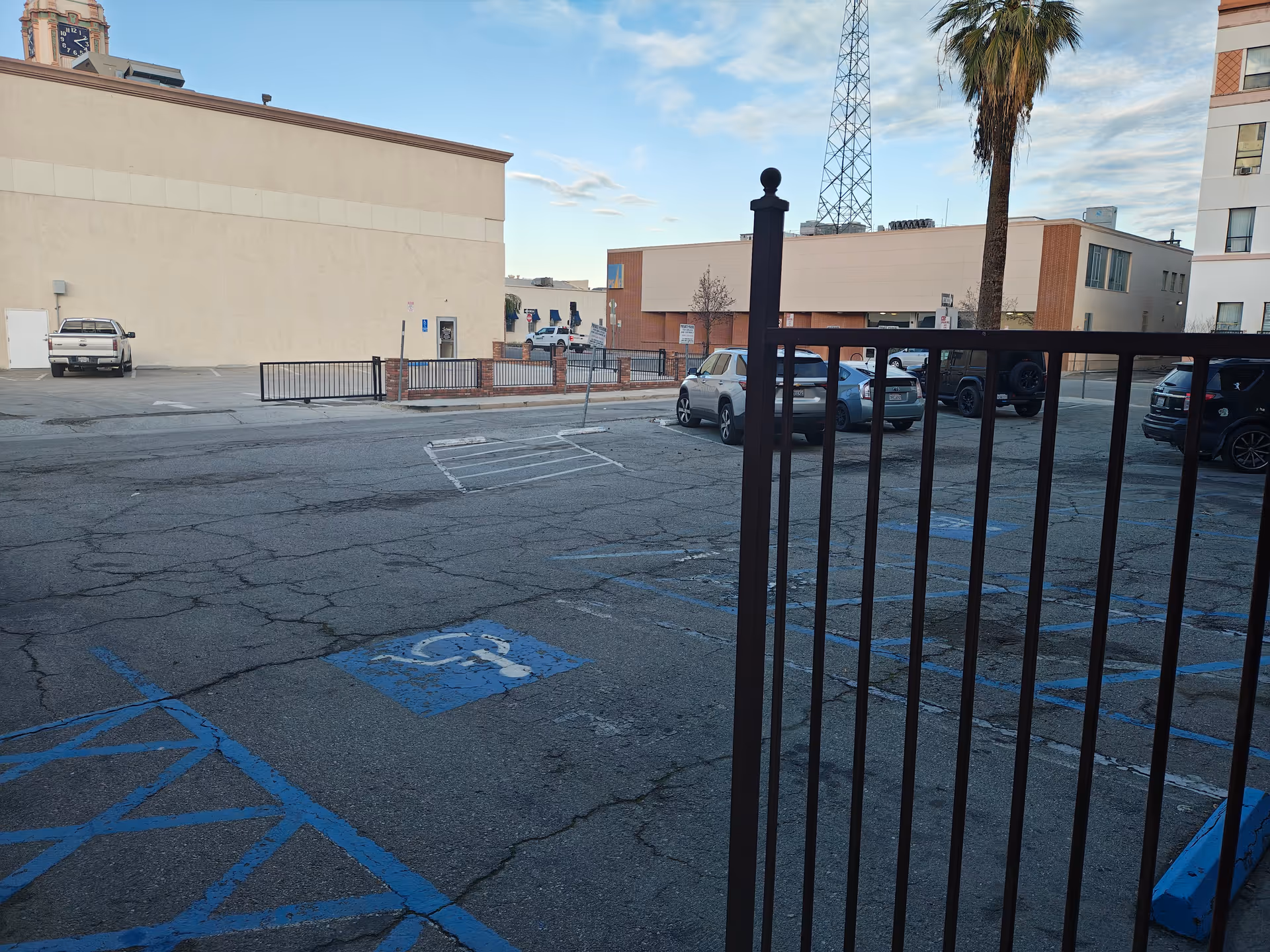 Exterior view of parking lot in front of a senior living facility with a metal railing.