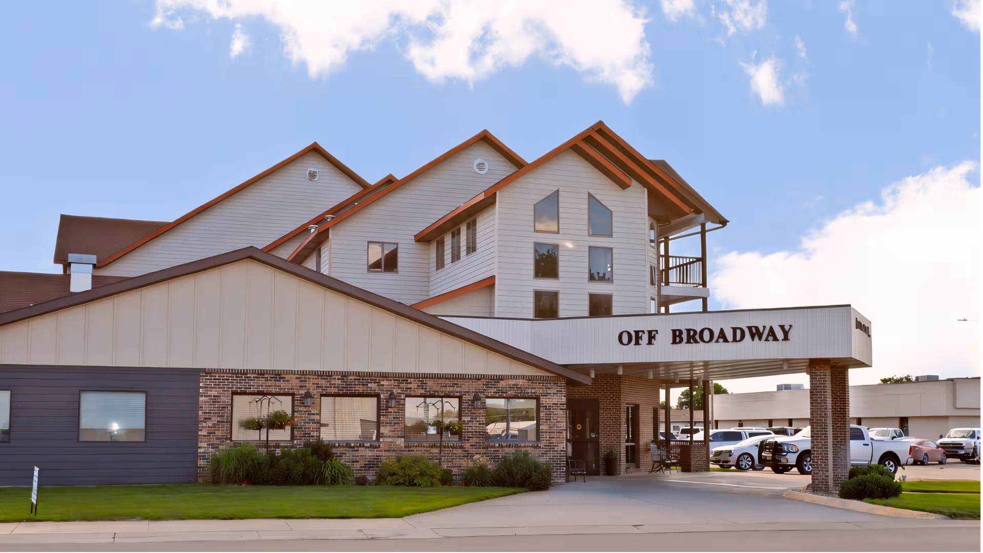 Exterior view of Off Broadway Assisted and Independent Living building with parking.