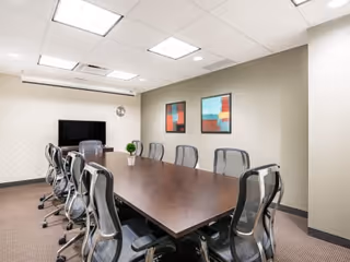 Conference room in Easy Living Assistance with long table, chairs, and wall art.