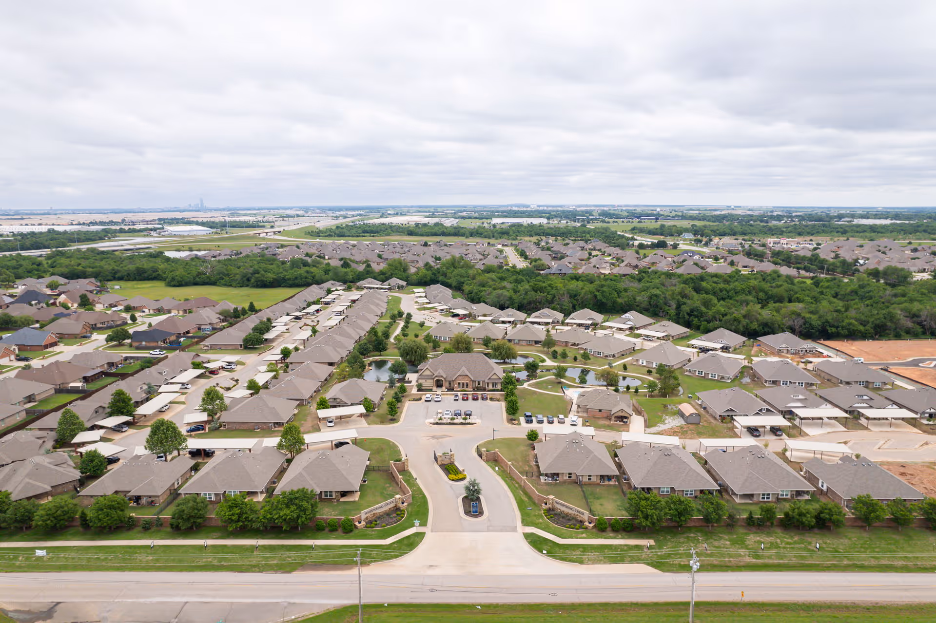 Aerial view of Whispering Creek senior living campus with beige-roofed housing units.