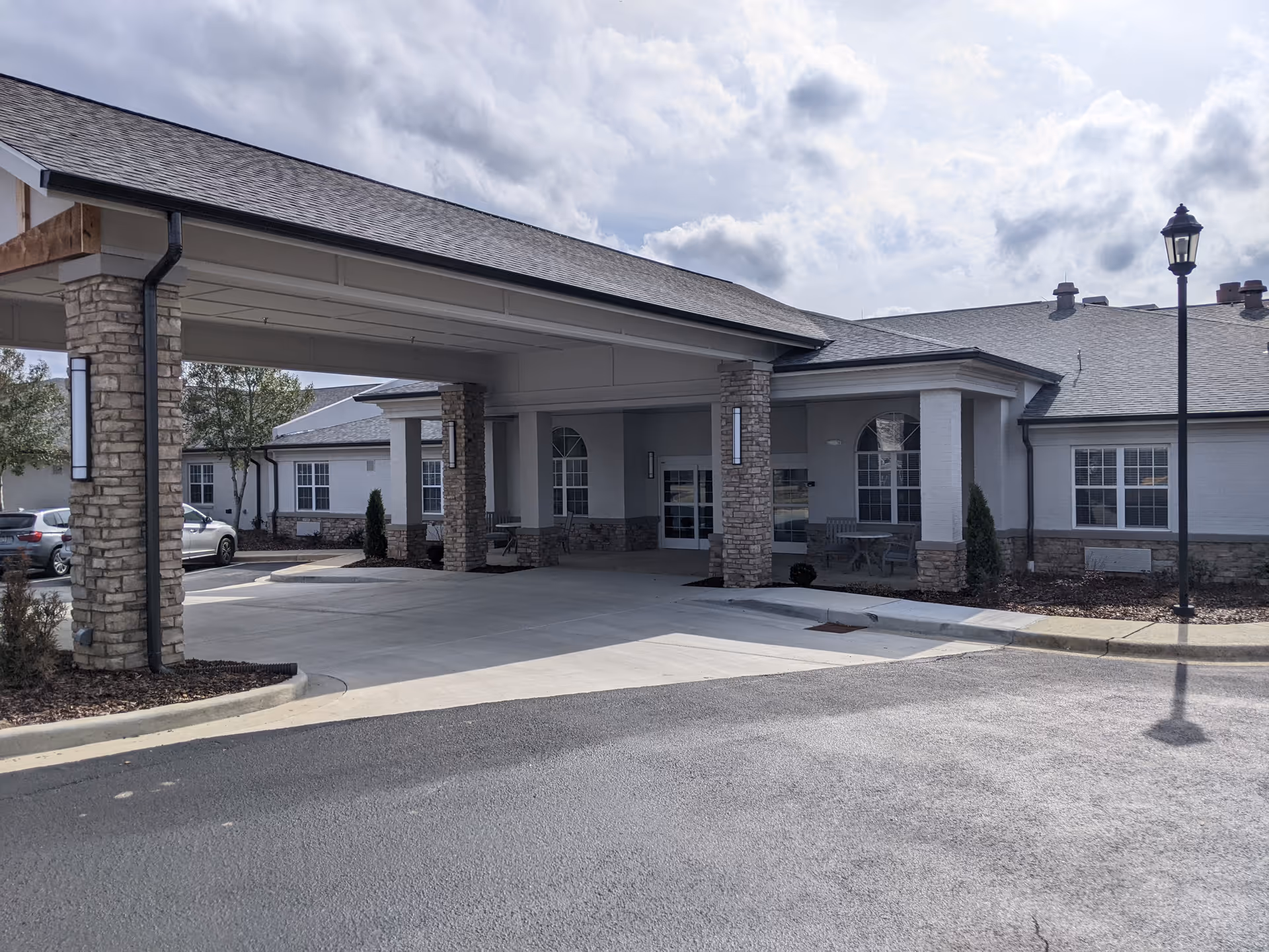 Exterior view of The Ridge at Grandeview entrance with porte-cochère and stone pillars.