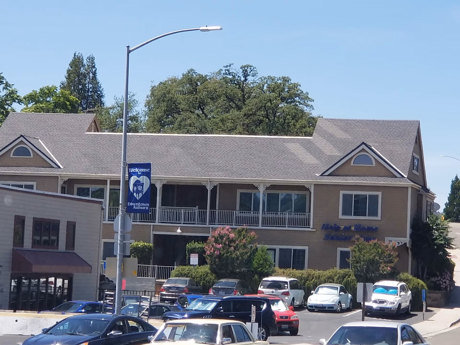 Exterior view of Help at Home Senior Care building with parked cars.
