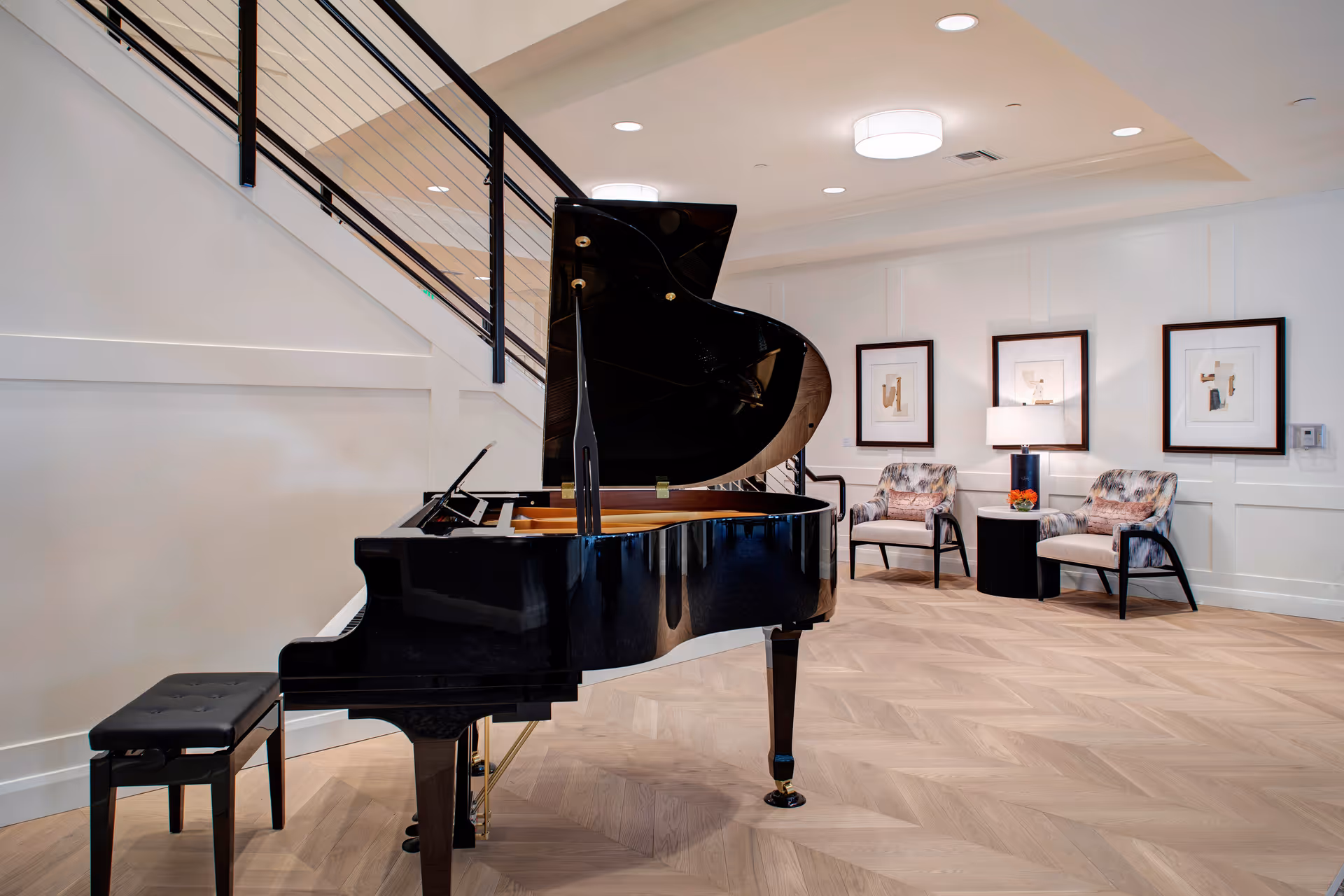A glossy grand piano sits in a bright senior living lounge with artwork.