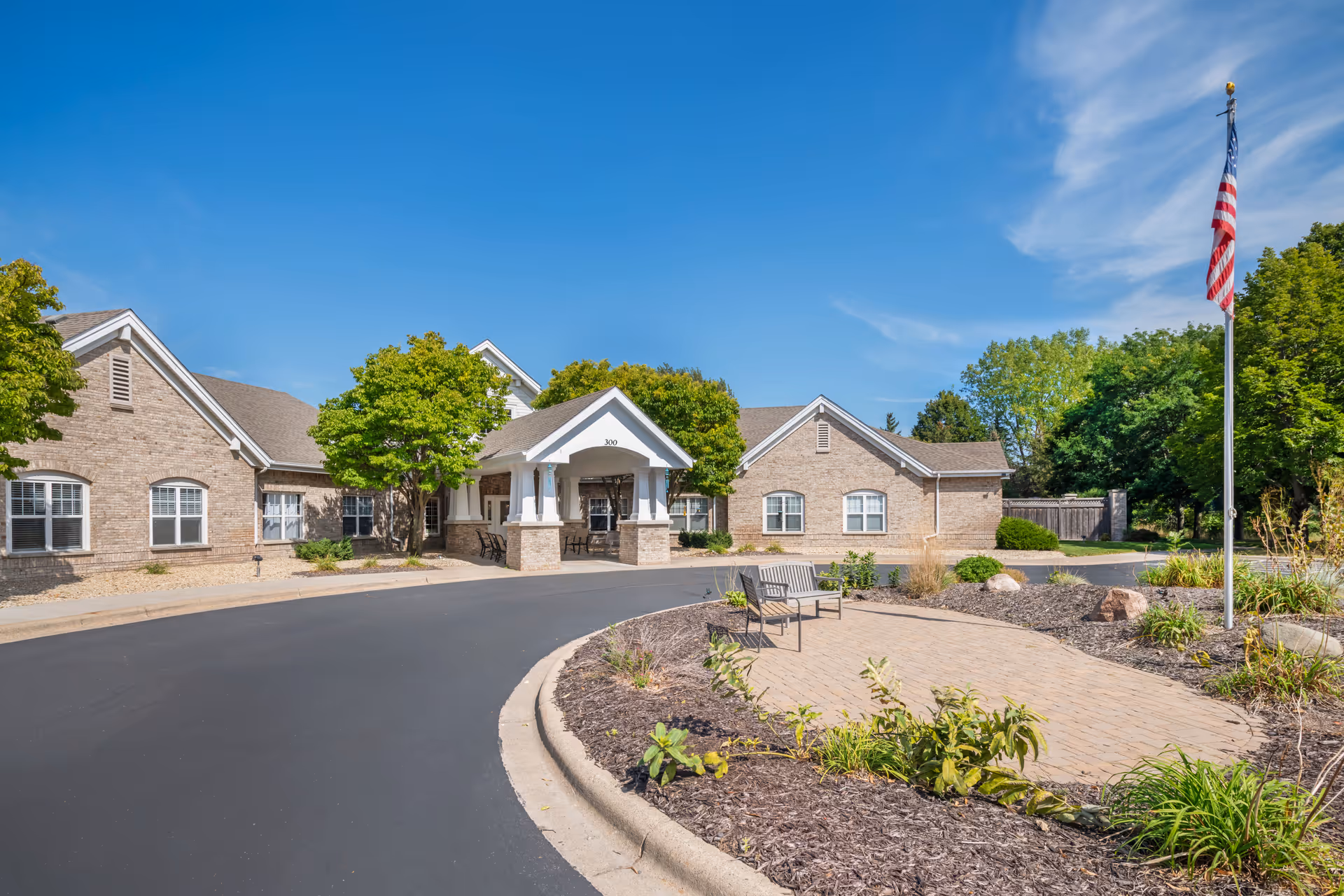 Front view of a Brookdale North Oaks senior living facility with entrance canopy and flag.